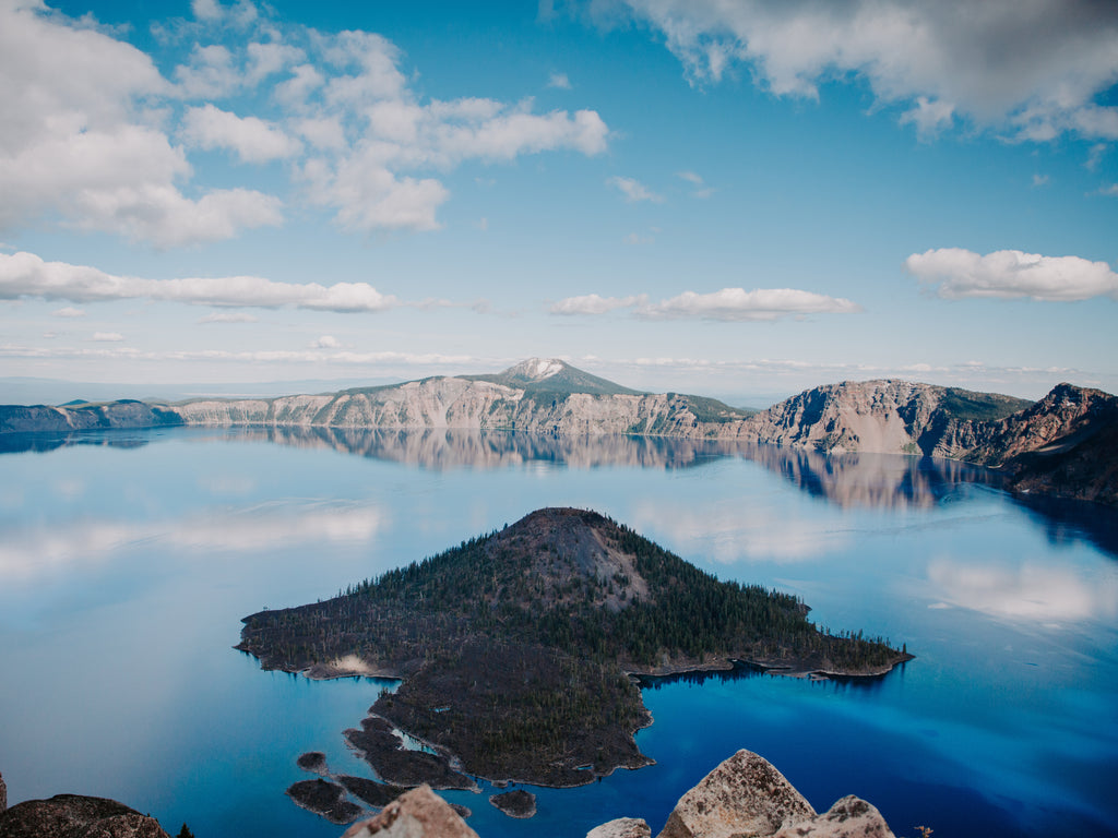 Lake with a small island and mountains in the background
